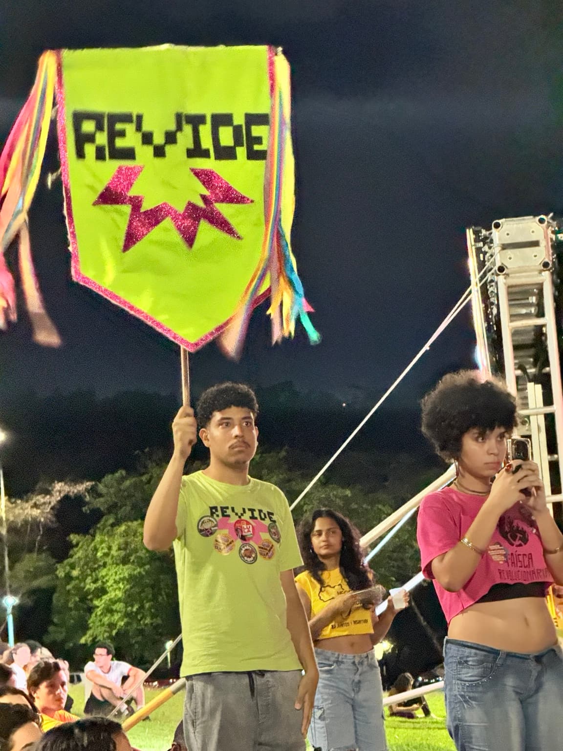 Participantes com estandarte do coletivo Revide durante a assembleia estudantil na UFMG