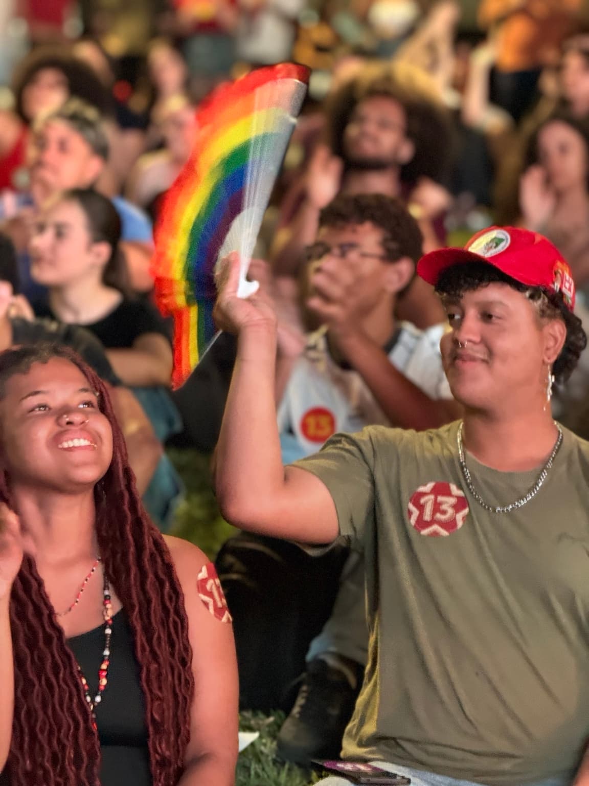 Estudantes com adesivos de Lula e leque com as cores do arco-íris na assembleia da UFMG