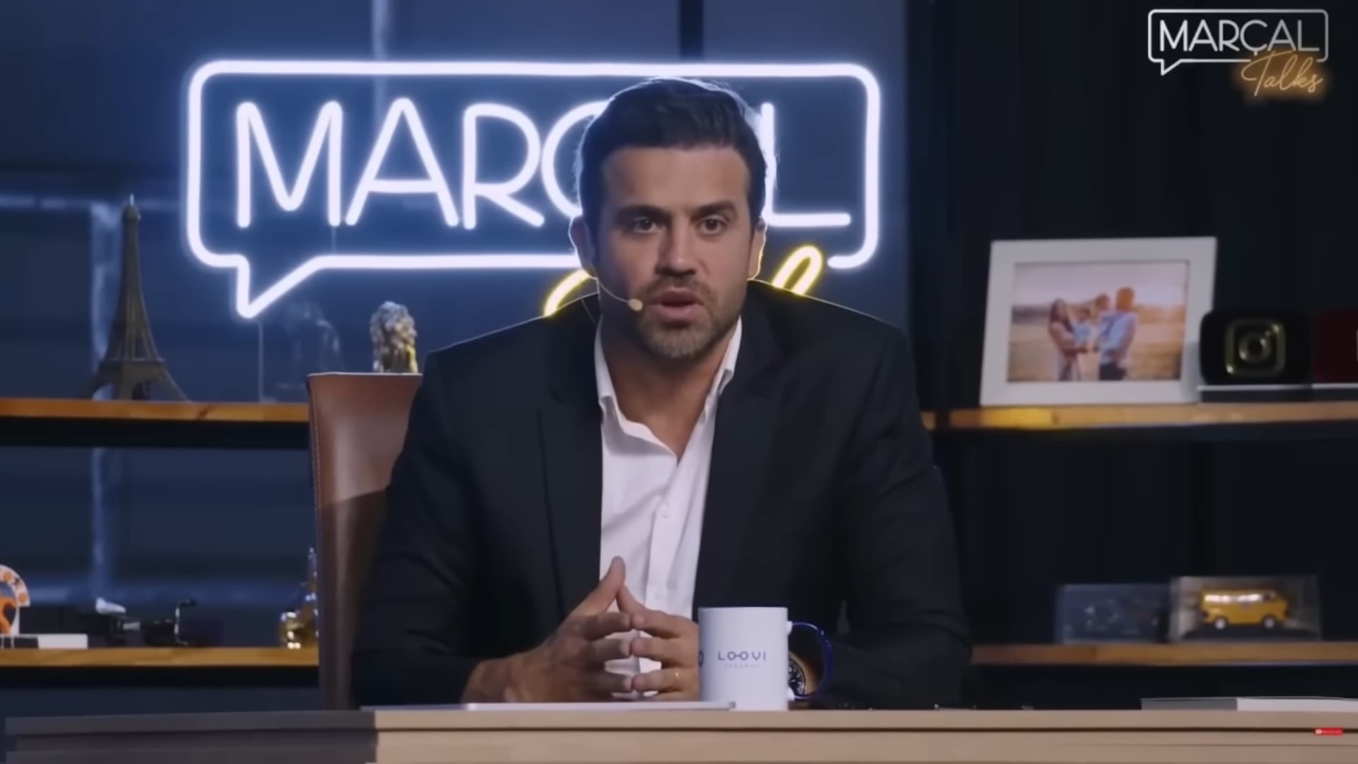 Pablo Marçal, de paletó escuro e camisa branca, fala ao microfone no estúdio do Marçal Talks em maio de 2024. Registro documental de arquivo.
