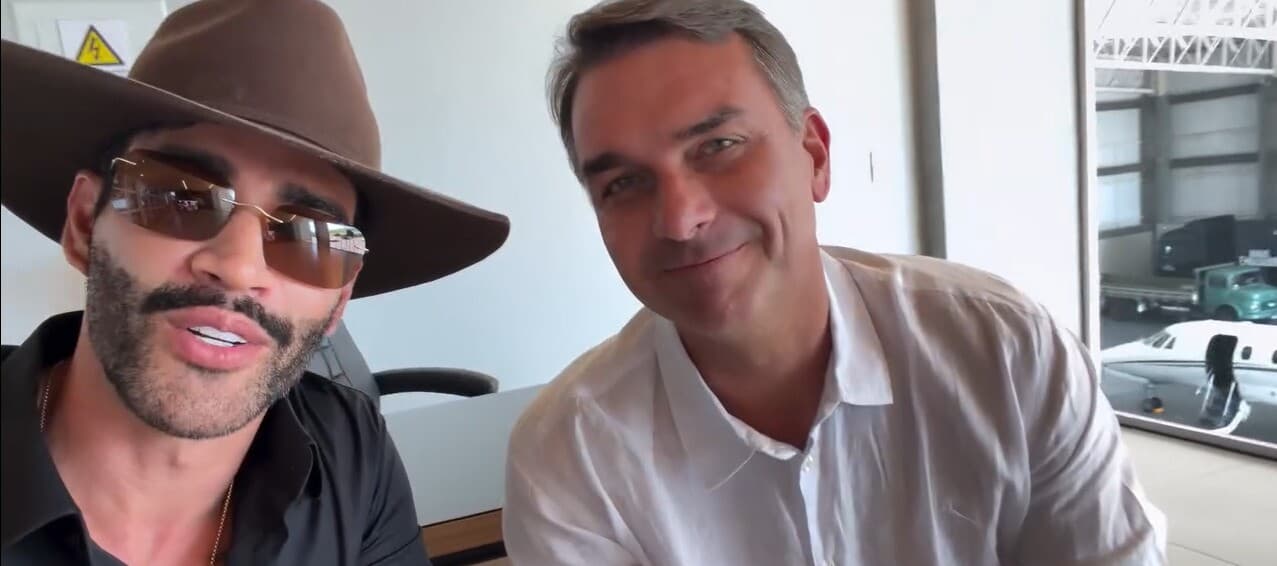 Gusttavo Lima, de chapéu e óculos escuros, aparece ao lado de Flávio Bolsonaro em vídeo de apoio divulgado em 20 de outubro de 2026.