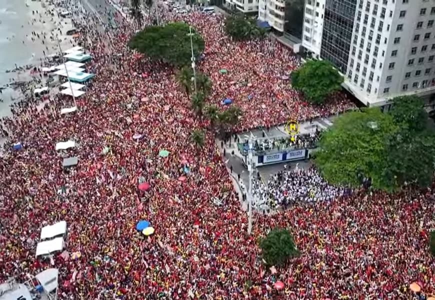 Vista elevada da multidão que ocupa a Avenida Atlântica e a praia de Copacabana durante o Ato Musical pela Democracia em 18 de outubro de 2026.