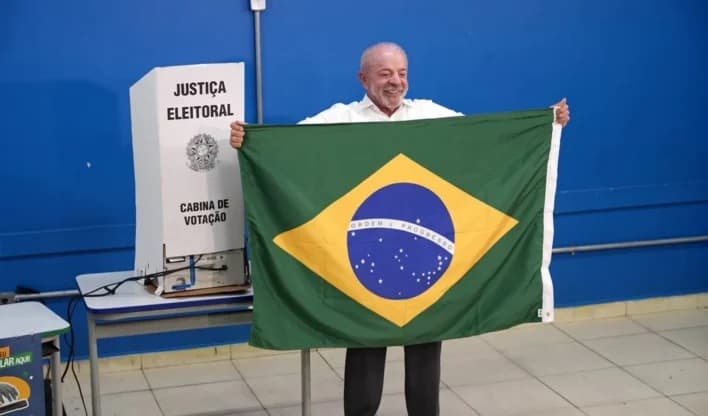 Lula segura a bandeira brasileira após votar em São Bernardo do Campo, na manhã de 25 de outubro de 2026.