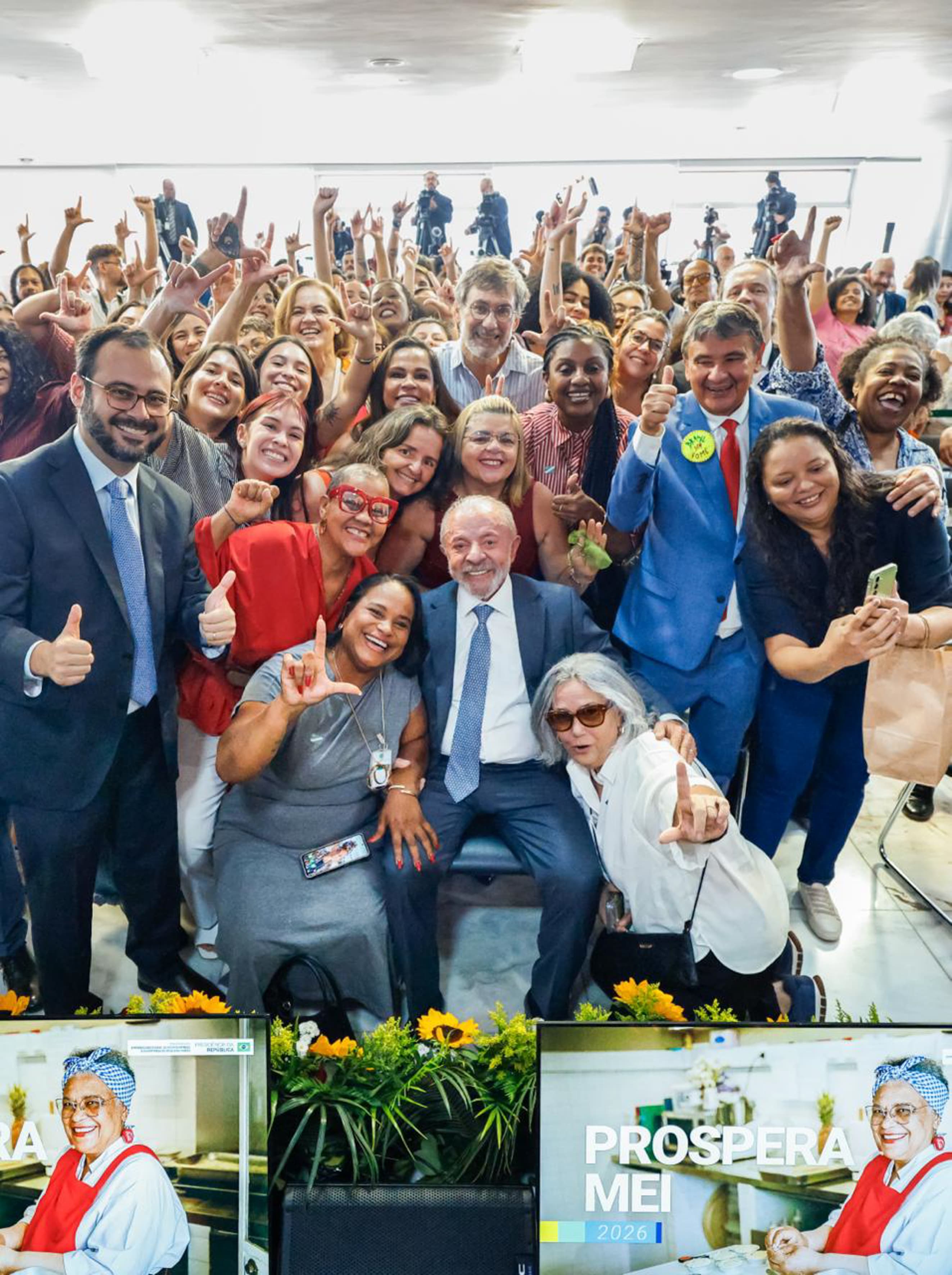 Lula posa com participantes da cerimônia de lançamento das medidas para microempreendedores individuais, no Palácio do Planalto, em 13 de outubro de 2026.