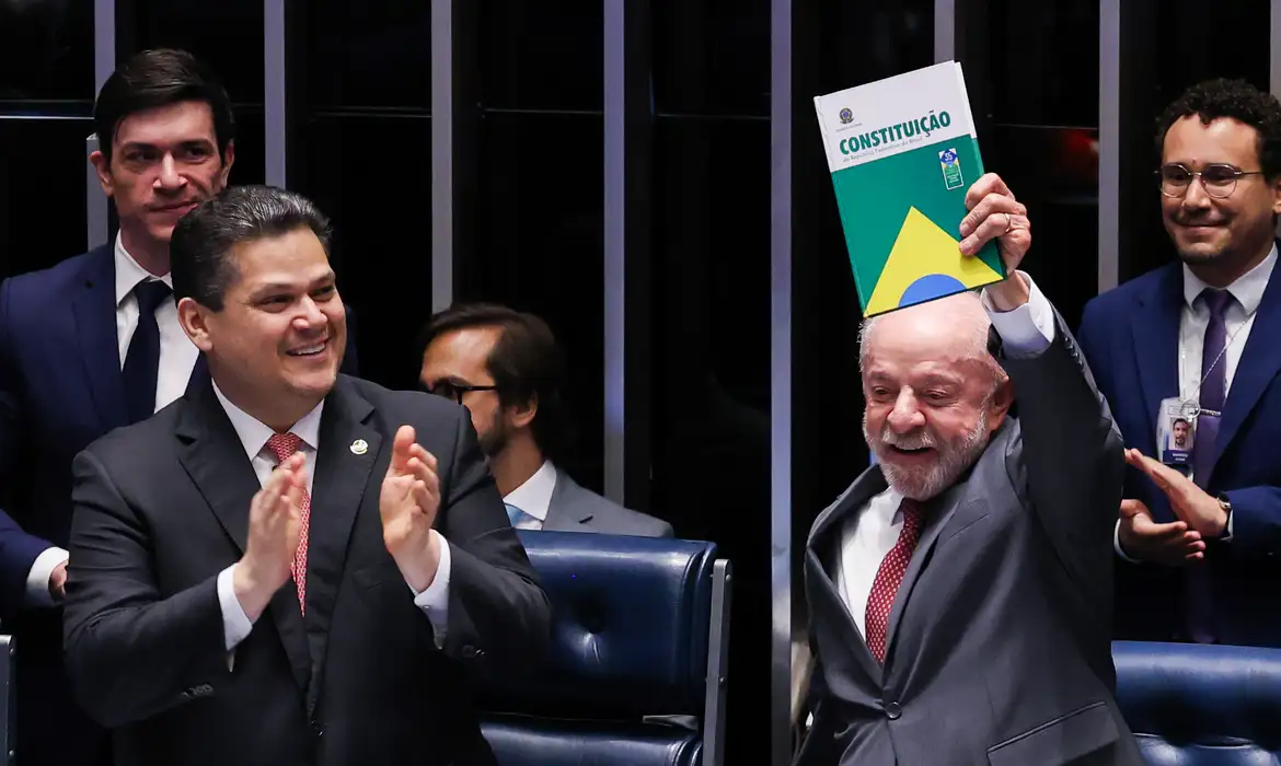 Lula ergue um exemplar da Constituição durante a promulgação do fim da escala 6x1, no Congresso.
