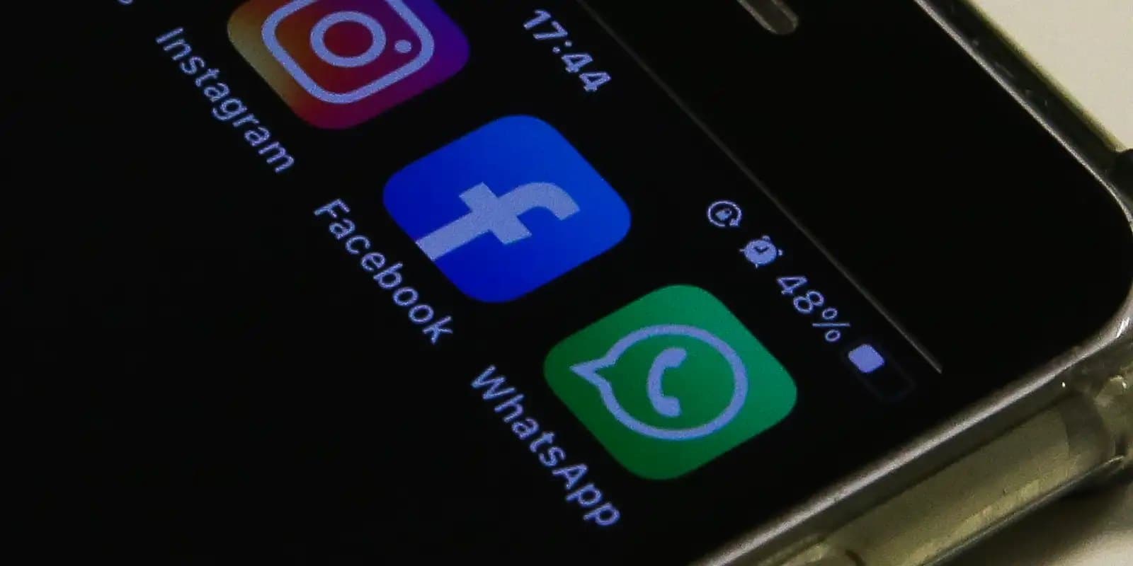 Close-up da tela de um celular exibindo os ícones dos aplicativos Instagram, Facebook e WhatsApp.